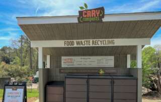 Picture of the food waste drop off in Cary, NC, looks like a shed with a nice sign and bins for food