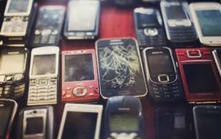 photo of old cell phones with cracked and broken screens