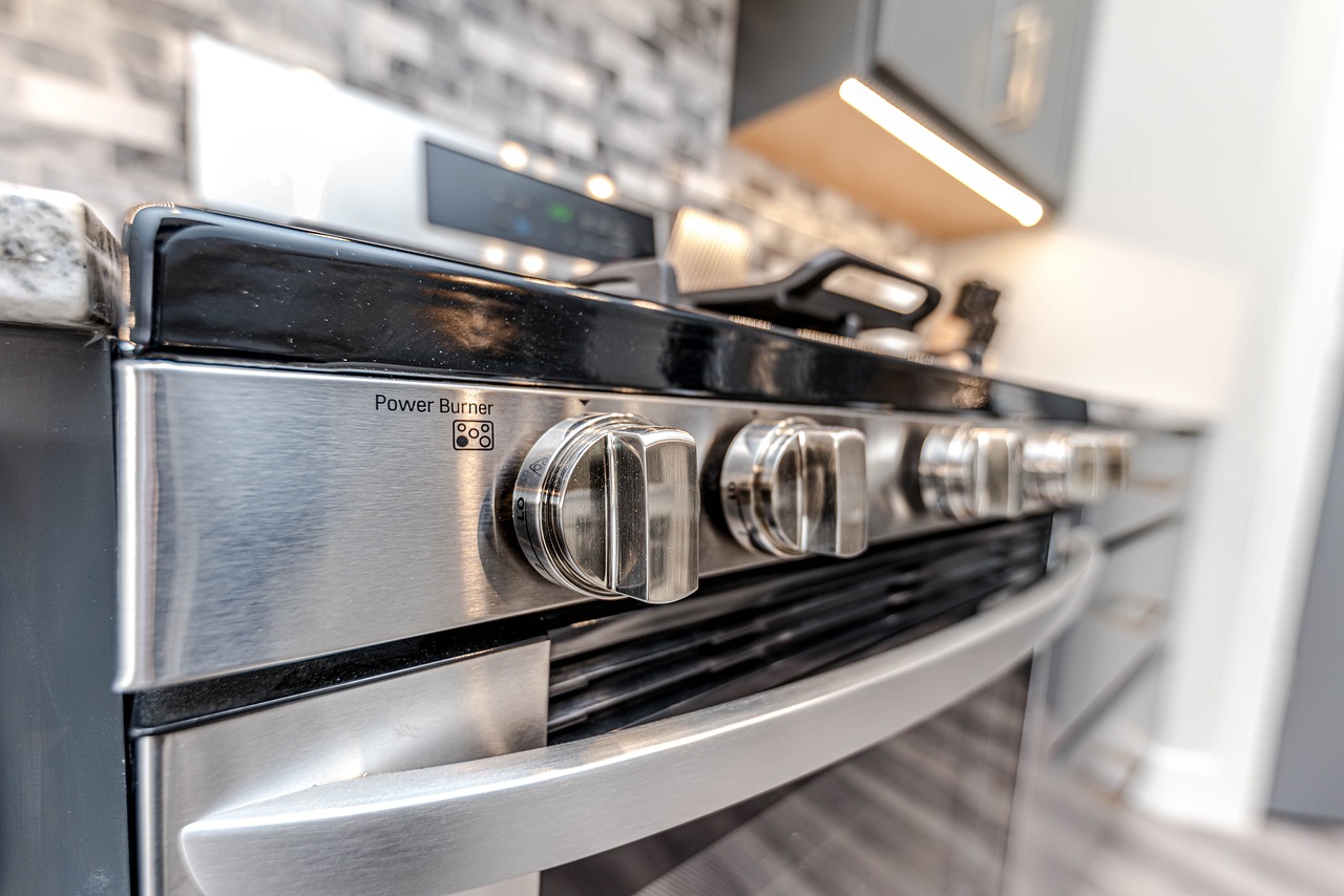 Photo of knobs on a stove in a brightly-lit kitchen