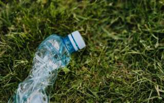 Photo of crushed plastic bottle on grass.