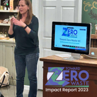 Board Chair Dawn Comfort stands beside a desk at Mindful Merchant in Cary giving a Toward Zero Waste 101 presentation